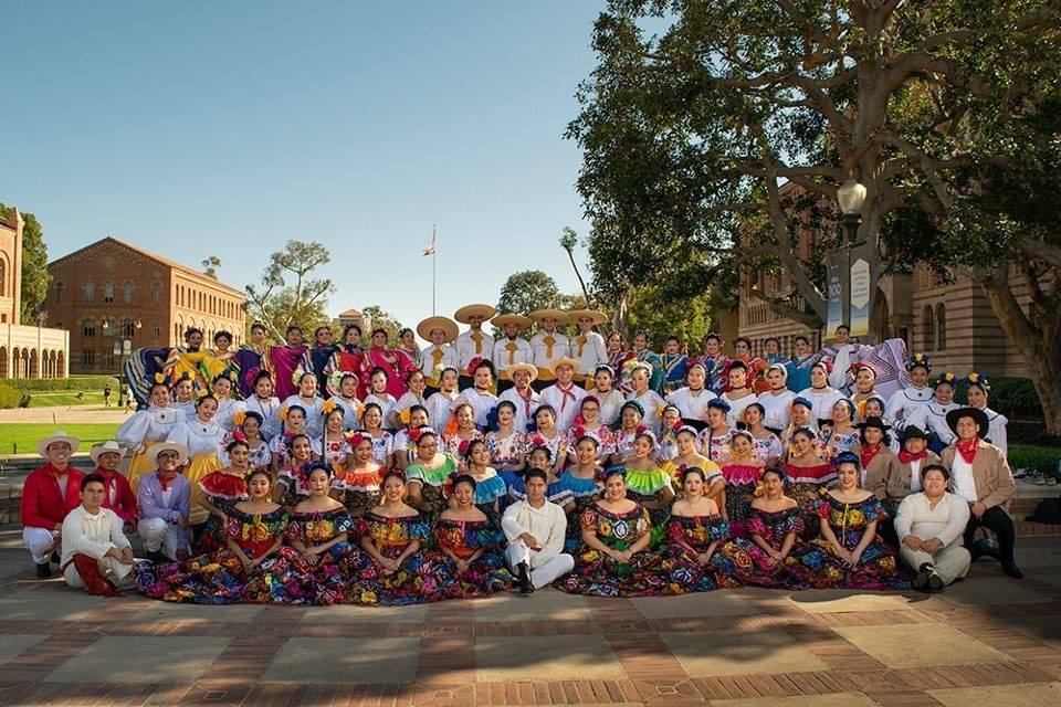 Approx. 50 folklorico dancers outside wearing traditional garment (white, red, blue, pink)