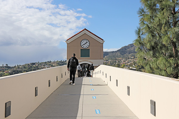 Students crossing bridge towards clock tower