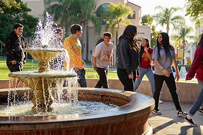 Students walking by fountain