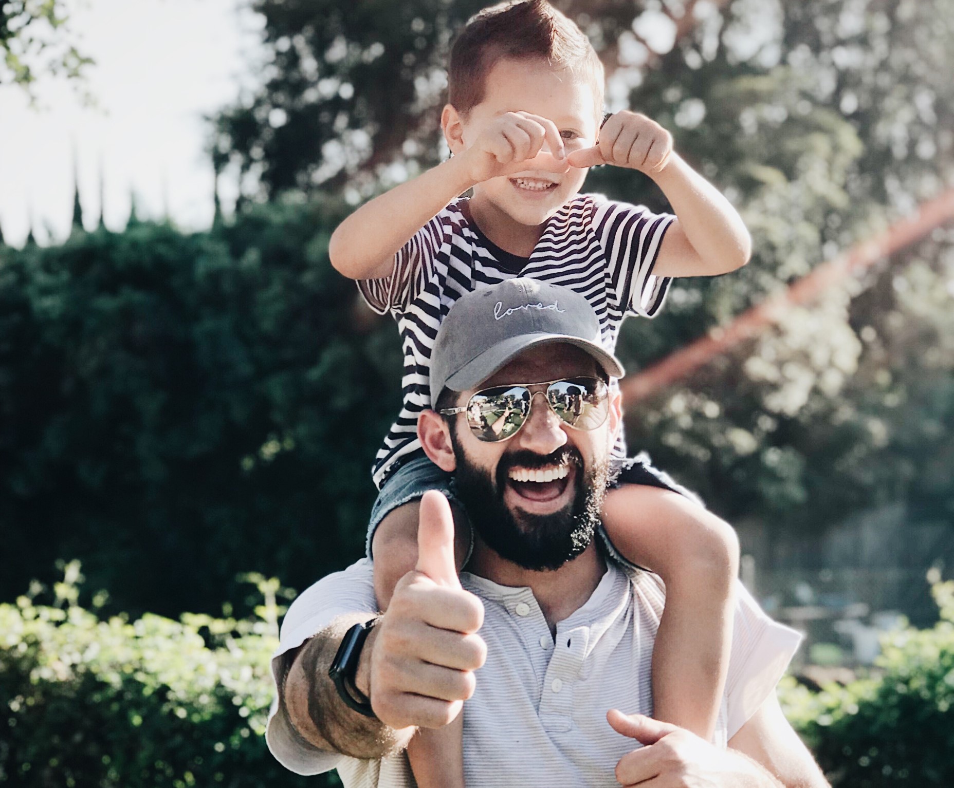 Dad with beard with child on shoulders, dad thumbs-up